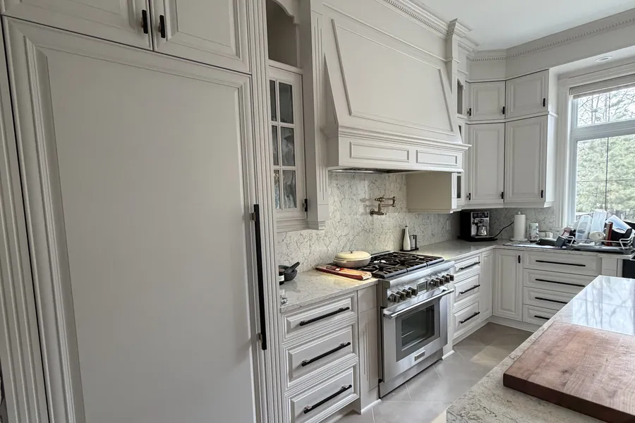 Panneau du réfrigérateur, armoires du haut et cuisinière de la même cuisine